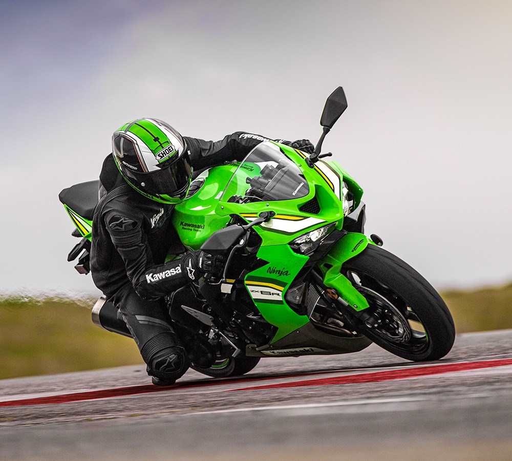 Rider leaning a green Kawasaki Ninja through a track corner